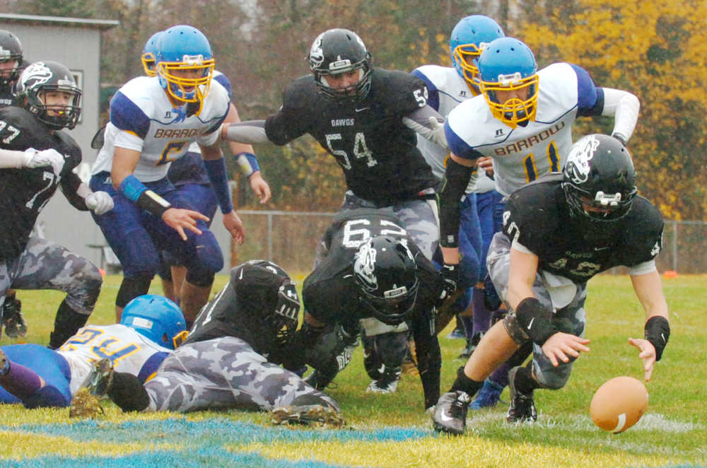 Ben Boettger/Peninsula Clarion Nikiski High School football player Nathan Carstens picks up a fumble in the Nikiski endzone during a game against Barrow on Saturday Oct. 10 at Nikiski High School.