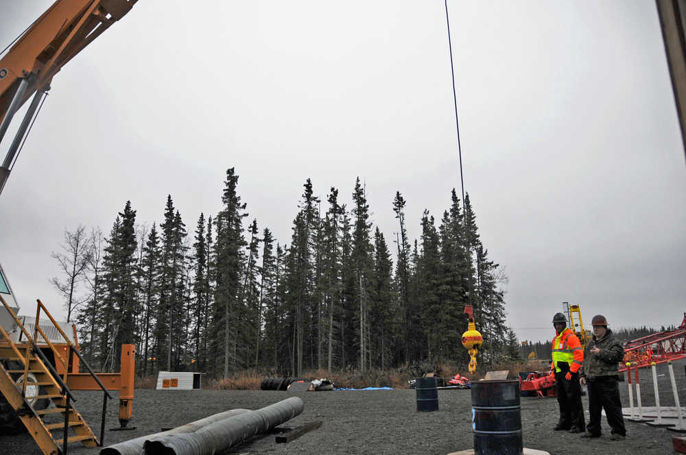 Bill Elmore and Daniel Barry watch and time Brandon Leary as he attempts to lower the auxiliary ball of a crane into a barrel, one of the certification practical exam requirements.