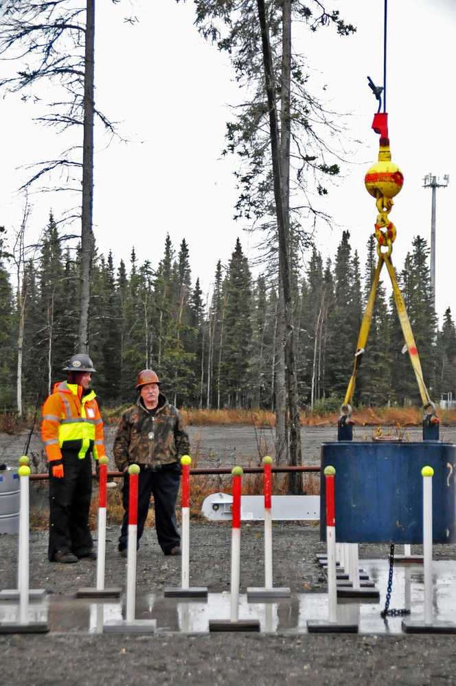 Bill Elmore and Daniel Barry watch as Brandon Leary completes the "zigzag test," in which he must navigate a test weight through a course while avoiding the poles.