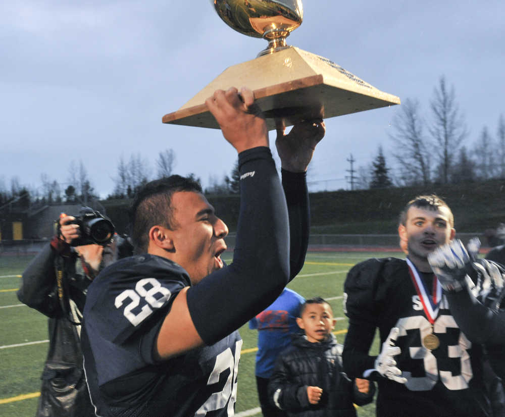 Drew Gibbs brings the trophy to his teammmates.  Photo for the Clarion by Michael Dinneen