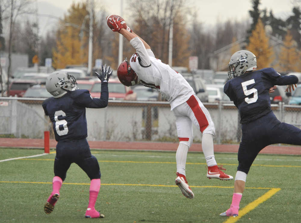 Kenai's Zack Tutle catches a touchdown pass between Soldotna's Dylan Simons, 5 and Jesse Littrel.  Photo for the Clarion by Michael Dinneen