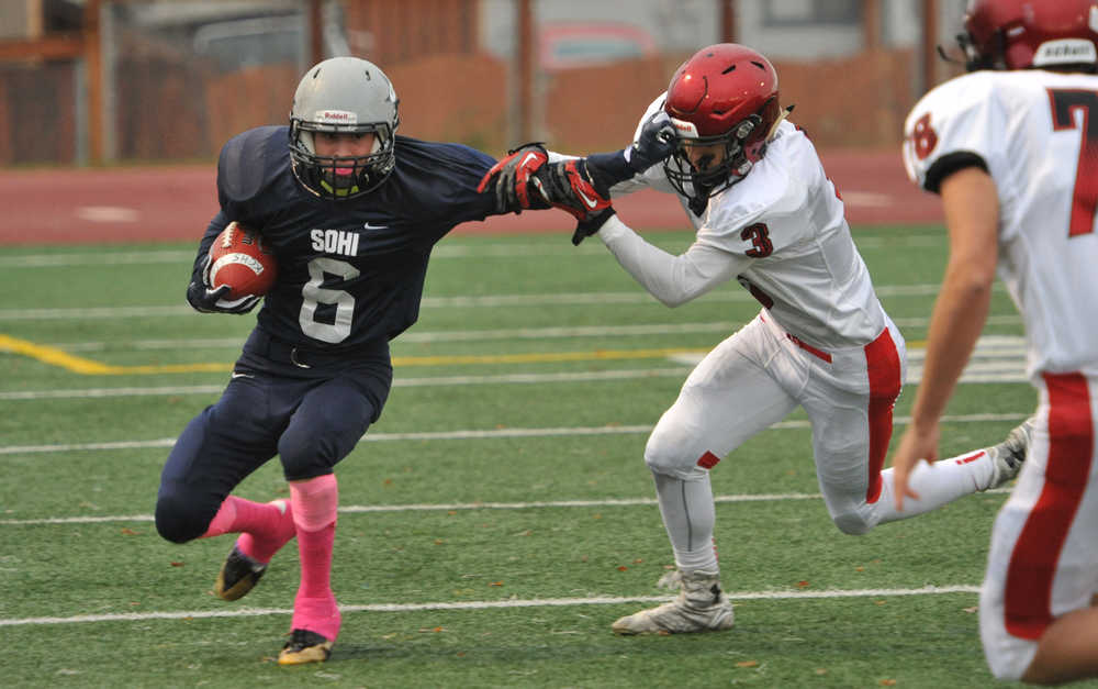 Soldotna's Jesse Littrel stiff arms Kenai's Keith Ivy on a kickoff return.  Photo for the Clarion by Michael Dinneen