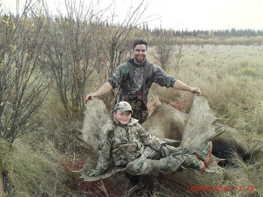 Jackson (front) and Tad Covault pose with the moose Jackson shot down in September north of the Yukon River.