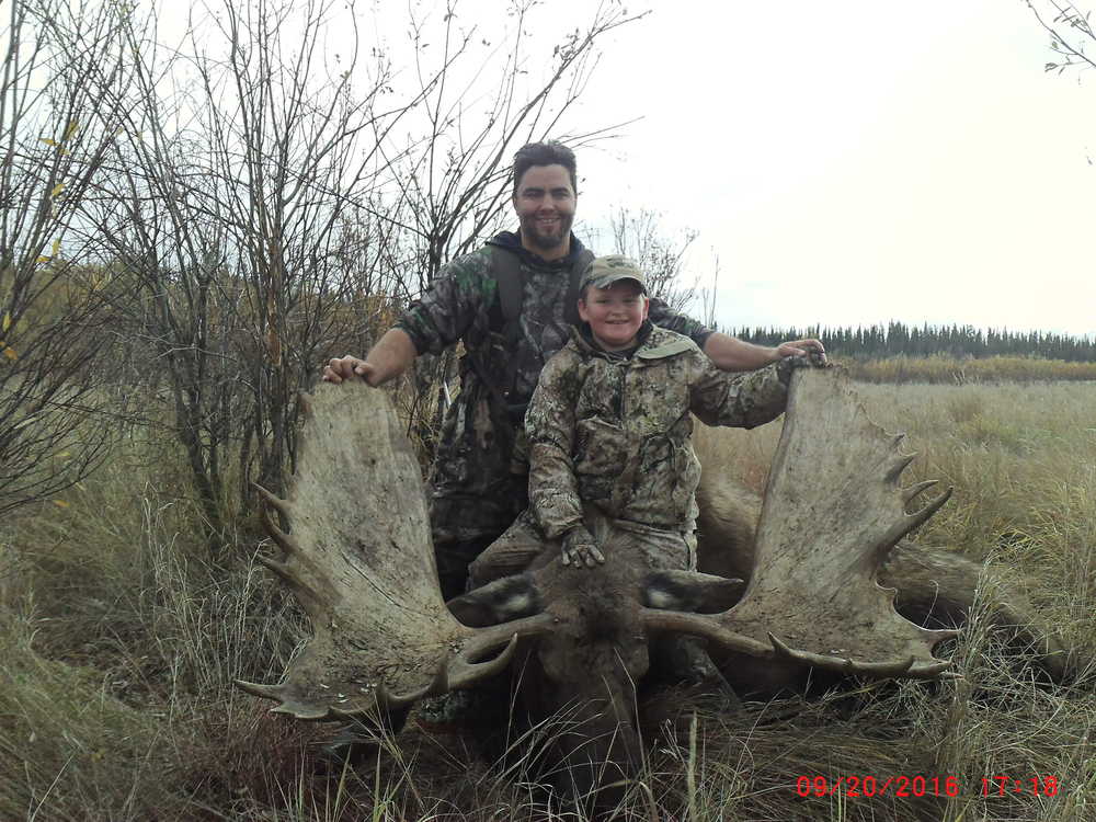 Jackson (front) and Tad Covault pose with the moose Jackson shot down north of the Yukon River in September.