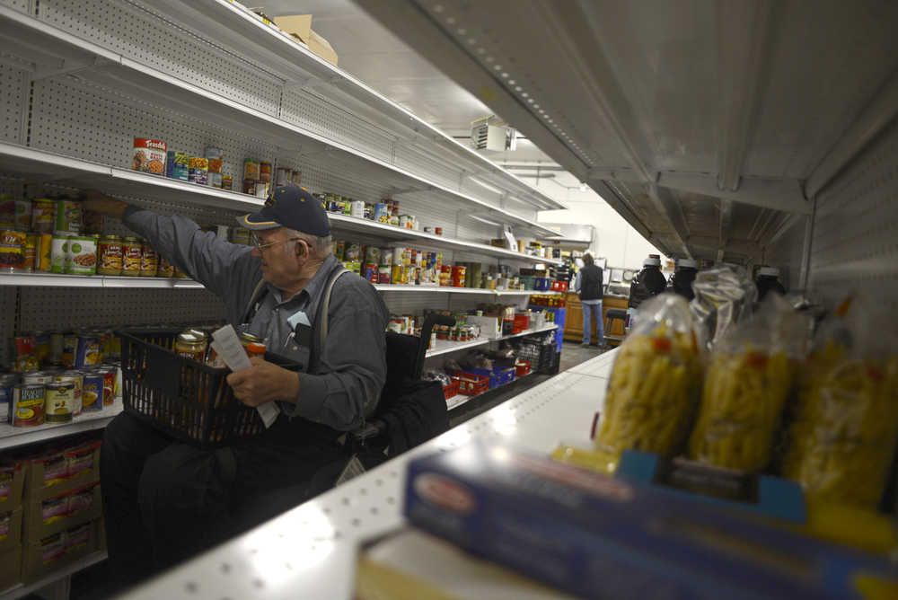 Photo by Rashah McChesney/Peninsula Clarion  In this Oct. 30, 2013 file photo Harry Moore, of Soldotna, stocks shelves at the Kenai Peninsula Food Bank in Soldotna, Alaska. The food bank received a new $10,000 grant to help fund operations.