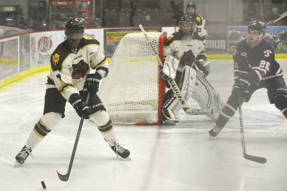 Ben Boettger/Peninsula Clarion Kenai hockey player Jeffrey Fasegha reaches for control of the puck, soon to be contested by  Brendan Jaquay, during a game on Friday Oct. 23 at the Soldotna Sports Center.