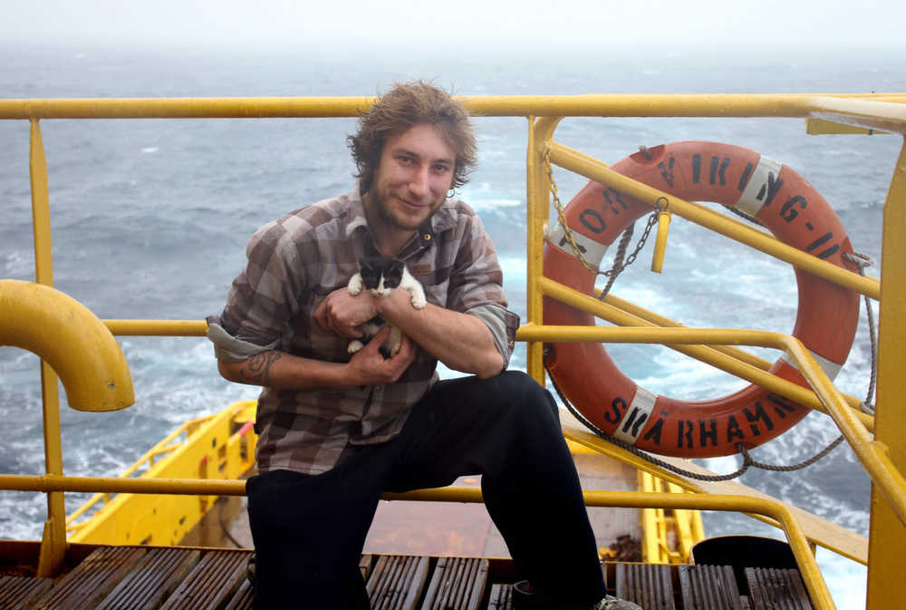 This photo courtesy of Emmanuel Wattecamps-Etienne, shows him posing for a photo with his cat.  Wattecamps-Etienne made a jump Tuesday, Oct. 20, 2015, from his sailboat, La Chimere, a rescue boat after the sailboat lost its rudder and rigging in high seas and gale force winds about 400 miles south of Cold Bay, Alaska. He tucked his cat inside his coat before making the leap off the doomed sailboat. (Courtesy of Emmanuel Wattecamps-Etienne via AP)