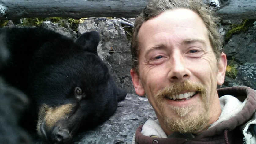 Courtesy photo/Bruce Manlick Michigan native Bruce Manlick poses with a female black bear he shot on Friday, Oct. 2, 2015 near Cottonwood Creek Trail in the Kenai National Wildlife Refuge. Manlick was rescued by fishermen when his kayak tipped over on Skilak Lake the day after he shot the bear.