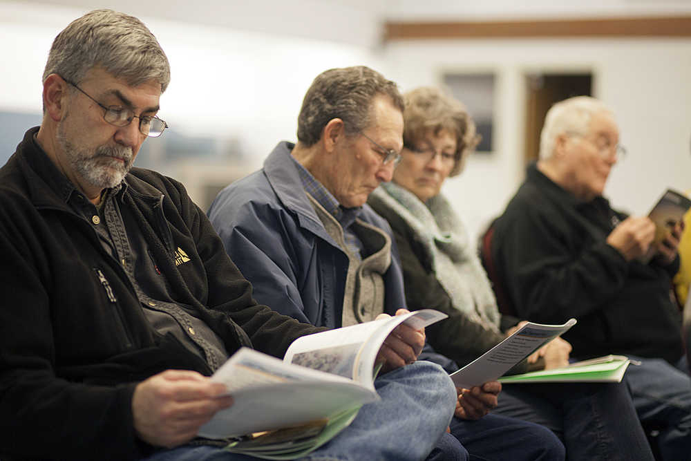 Photos by Rashah McChesney/Peninsula Clarion A handful of the more than 80 people who attended a Federal Energy Regulatory Commission read through a handout from the Alaska LNG project during the meeting on Wednesday October 27, 2015 in Nikiski, Alaska.