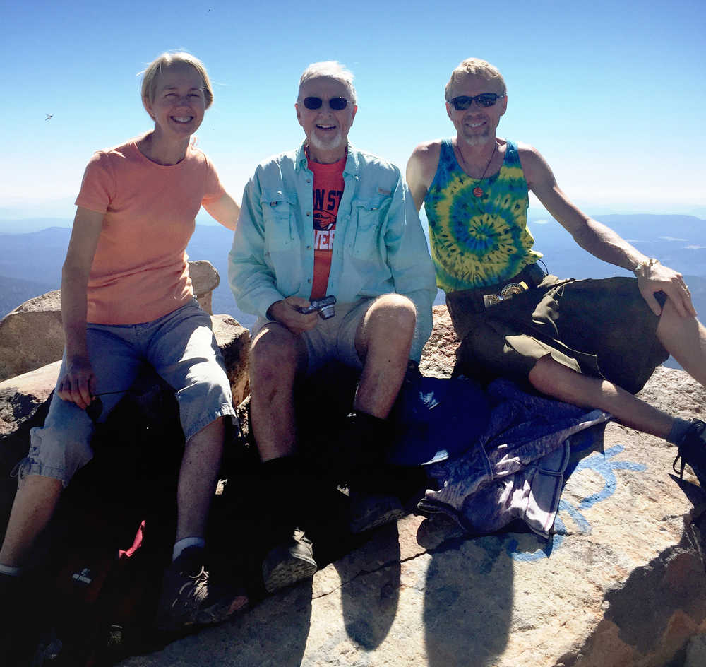 In this photo taken Sept. 15, 2015 and provided by Art Ekerson, Ekerson center, sits on the summit of Mount McLoughlin for his 80th birthday near Butte Falls, Ore.,with his daughter, Cheryl Krieg, left, and son Kevin Ekerson, 45 years after the first time he led them to the summit.   During the previous 41 times climbing to the top of Mount McLoughlin, Art Ekerson would soak up the views of Southern Oregon and Northern California in a panorama like none other.  But trip No. 42 had a distinctly familial feel. (Art Ekerson via AP) MANDATORY CREDIT