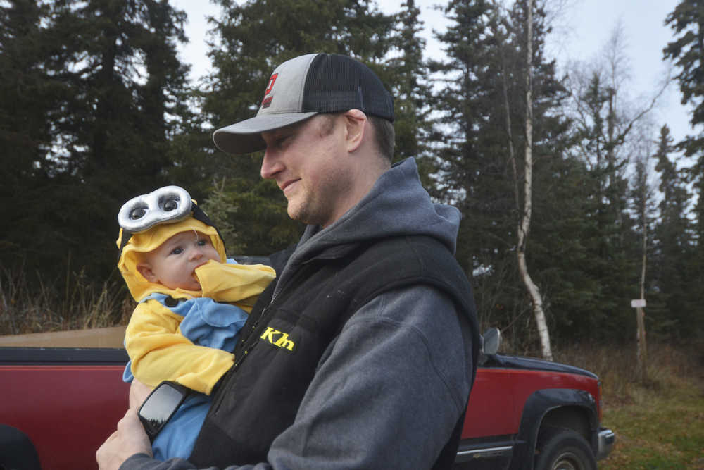 Photo by Megan Pacer/Peninsula Clarion Soldotna resident Austin Bundy holds his nearly 6-month-old son, Sullivan, while walking along the Tsalteshi Trails during the 2015 Spook Night Trick or Treat and Zombie 5K on Sunday, Oct. 25, 2015 in Soldotna, Alaska.