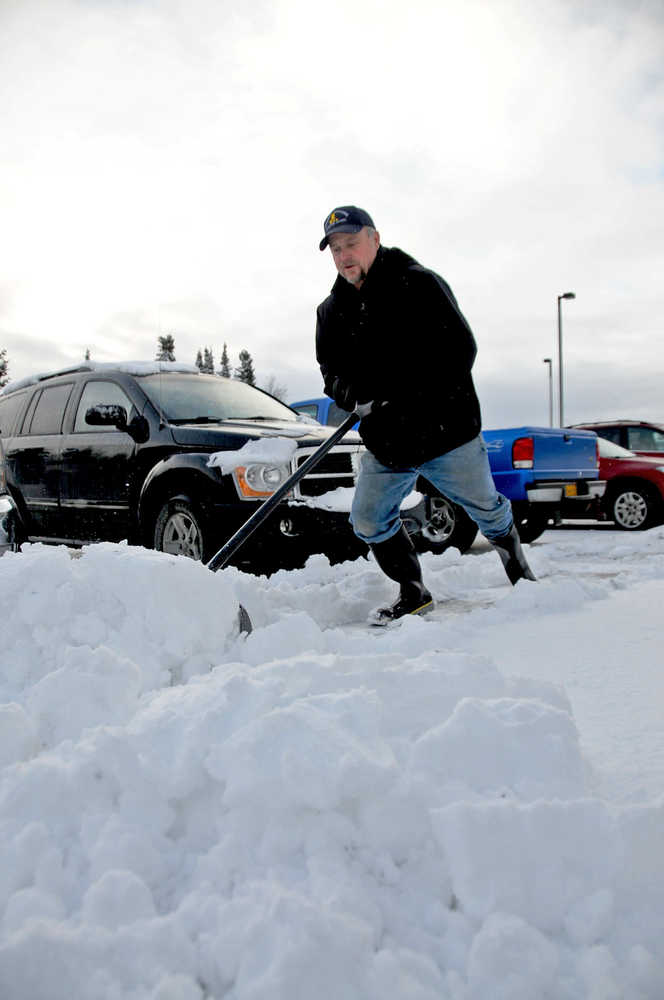 Tom White of Integrity Janitorial clears snow from the sidewalk of the Kenai Courthouse Tuesday after several inches of snow fell Monday night.