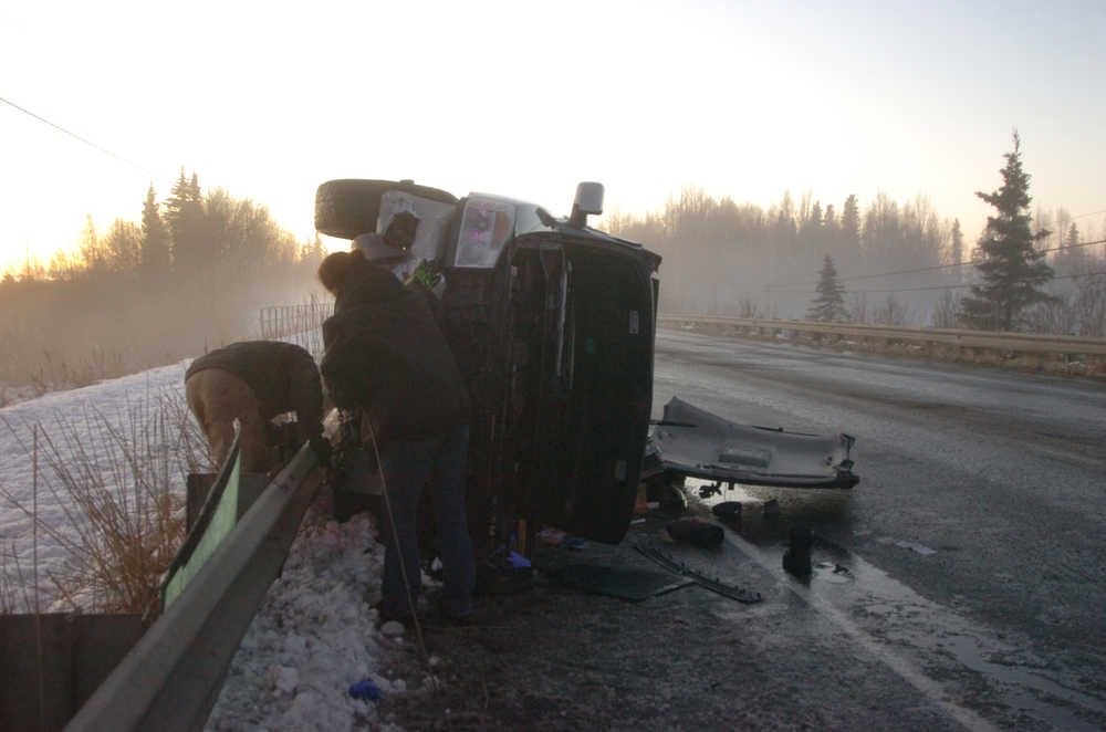 Photo by Megan Pacer/Peninsula Clarion Members of Soldotna Y Towing prepare to haul a pickup truck off the road around mile 8 of the Kenai Spur Highway after its driver struck the guard rail on Tuesday, Nov. 3, 2015 in Kenai, Alaska. The driver was taken to Central Peninsula Hospital to be treated for injuries.