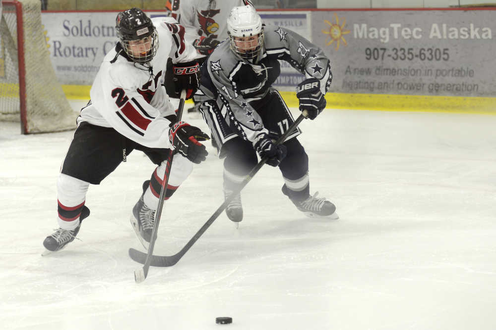 Ben Boettger/Peninsula Clarion Kenai hockey player Tristan Bulst (left) and Soldotna's Levi Hensley race for the puck during a game on Saturday, Nov. 7 at the Soldotna Regional Sports Complex.