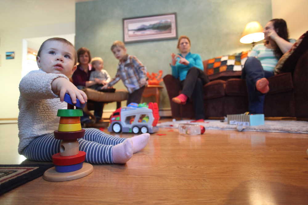 Photo by Kelly Sullivan/ Peninsula Clarion Nora Arness plays with toys while her mother Julie Arness chats with Kara Abel Thursday, Nov. 12, 2015, at Katy Bethune's home in Nikiski, Alaska. The three residents are hoping to start a parent's cooperative preschool in the community.