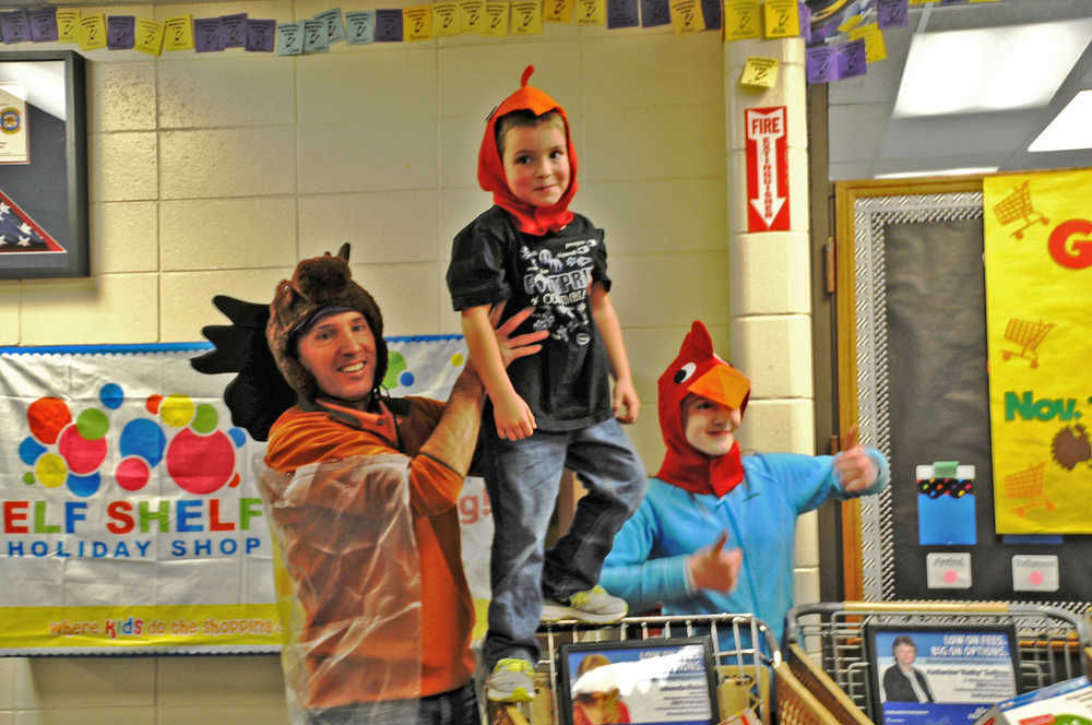 Photo by Elizabeth Earl/The Peninsula Clarion Borough Mayor Mike Navarre holds up Redoubt Elementary School kindergartener Dawson Harpole after their team won the annual Great Grocery Grab race on Friday.