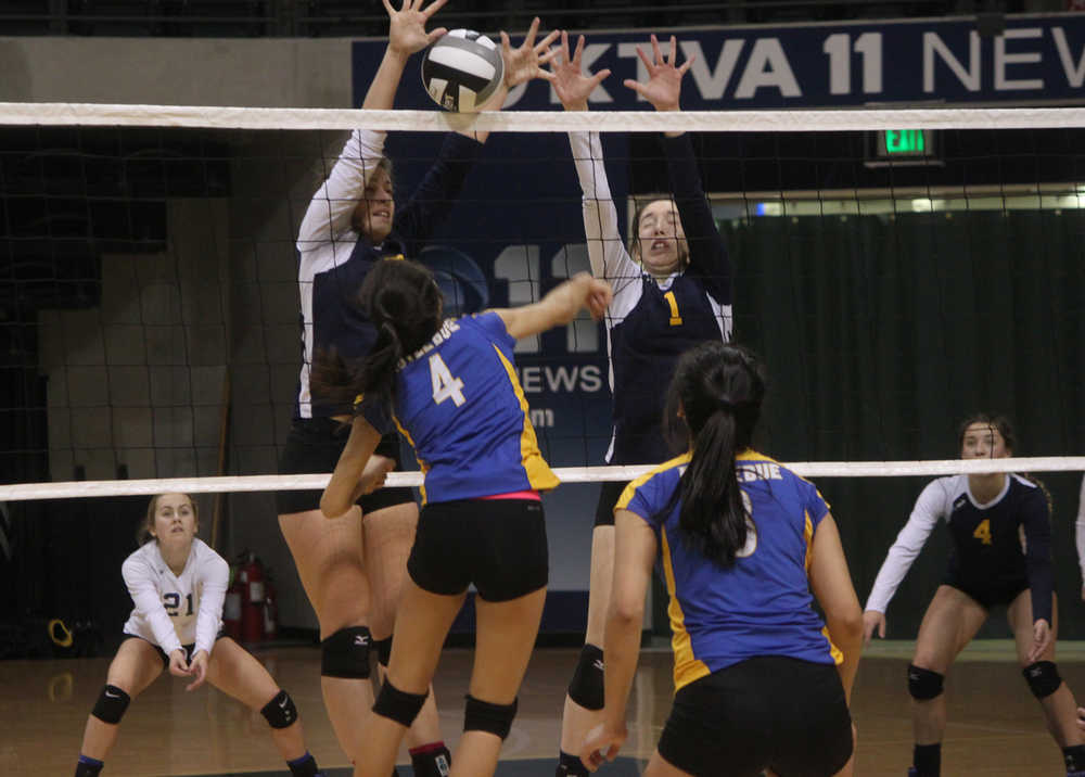 Photo by Joey Klecka/Peninsula Clarion Homer seniors McKi Needham and PK Woo (1) block a shot by Kotzebue sophomore Calia Sieh (4) Friday at the Class 3A state volleyball tournament at the Alaska Airlines Arena in Anchorage.