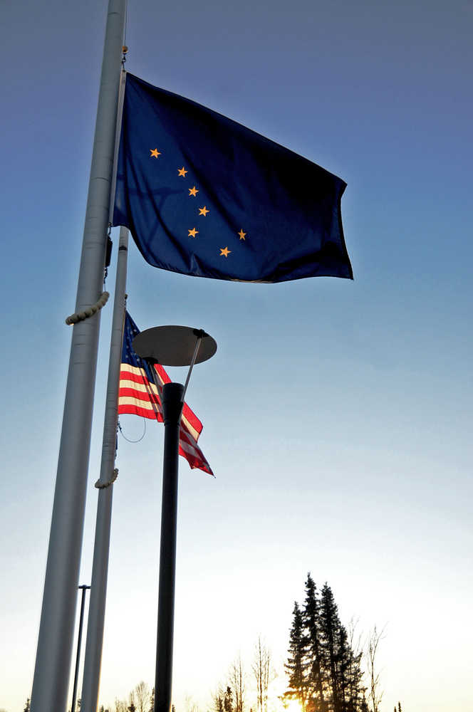 Photo by Elizabeth Earl/The Peninsula Clarion The flags at the Kenai Courthouse fly at half mast at sunset Monday. Alaska Gov. Bill Walker declared Sunday that all Alaska state flags be lowered to half mast in honor of the victims of the attacks in Paris on Friday. The flags will remain at half mast until Thursday.