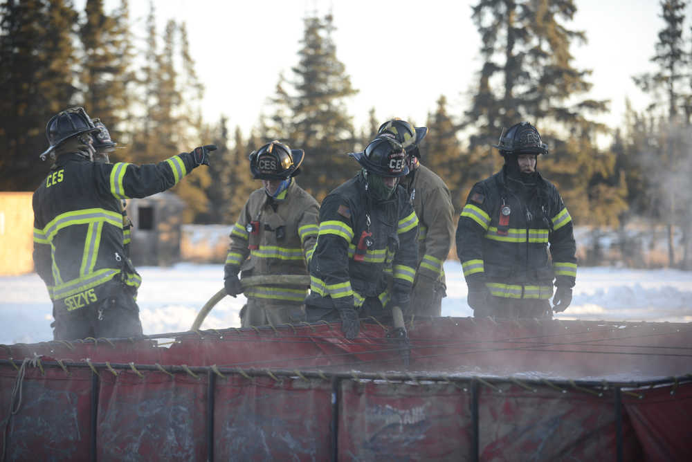 Photo by Megan Pacer/Peninsula Clarion Members of Central Emergency Services perform a drill called a changeover, in which they switch from one water source to another with one of the organization's engines, on Tuesday, Nov. 17, 2015 at the CES station on Kalifornsky Beach Road. Firefighters have been training for an upcoming engineering test for about two months.