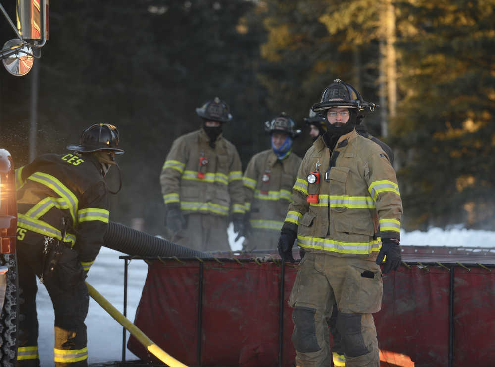 Photo by Megan Pacer/Peninsula Clarion Engineer Jay Morrison, right, leads Central Emergency Services firefighters through an exercise called a changeover on Tuesday, Nov. 17, 2015 at the organization's station on Kalifornsky Beach Road. The team practiced switching from one water source to another with one of their engines in preperation for an upcoming engineering test.