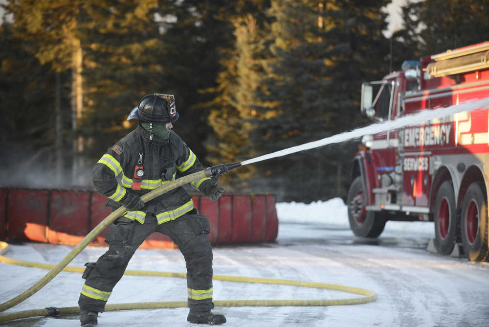 Photo by Megan Pacer/Peninsula Clarion Central Emergency Services firefighters fill a collapsable tank with water in preparation for a drill on Tuesday, Nov. 17, 2015 at the department's station on Kalifornsky Beach Road. The firefighters have been training for about two months for an upcoming engineering test.