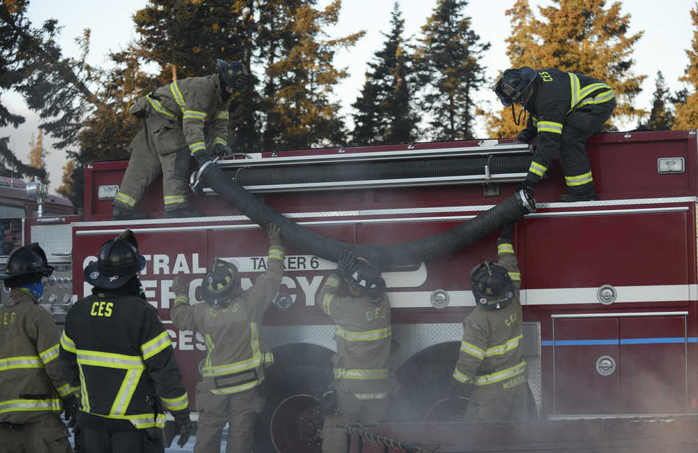 Photo by Megan Pacer/Peninsula Clarion Central Emergency Services Firefighter Jason Cooper aims a hose during practice drill on Tuesday, Nov. 17, 2015 at the department's station on Kalifornsky Beach Road. The firefighters have been training for about two months for an upcoming engineering test.