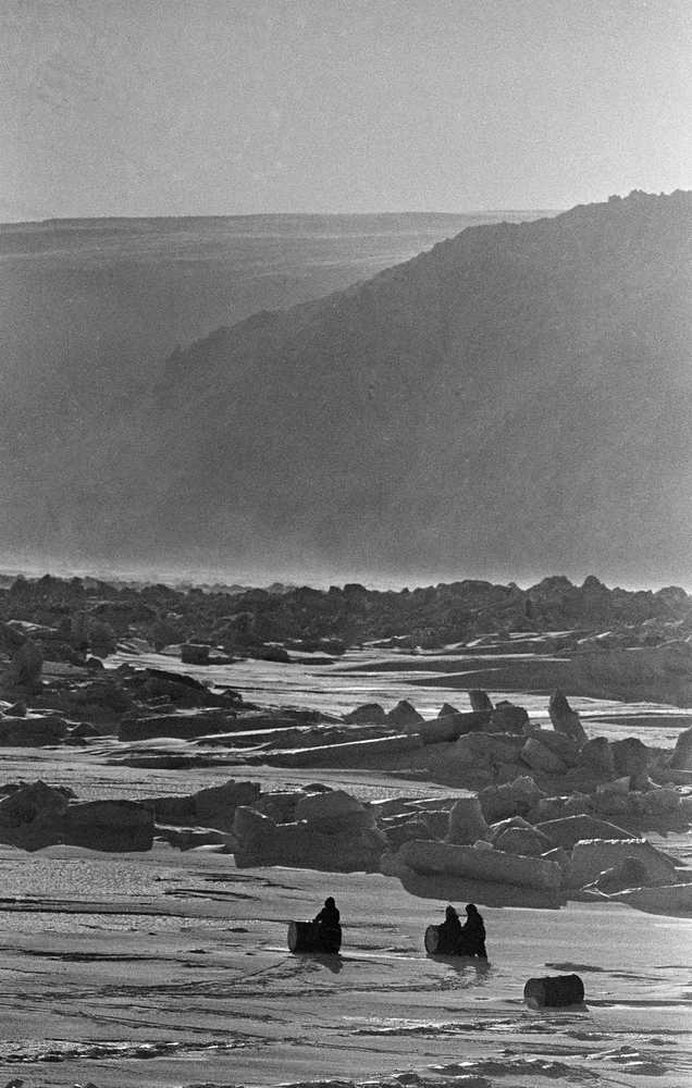 FILE - This May 1, 1970 file photo shows inhabitants of Little Diomede, rolling petrol drums over the frozen surface of the Bering Strait near their island home in Diomede, Alaska. The U.S. Coast Guard has laid out a 4-mile wide route through the Bering Sea into the Arctic Ocean and is reviewing public comment on whether it should become the first commercial shipping lane along Alaska's west coast. More Arctic sea ice melting each summer from global warming is making it easier for ships to plot routes through the environmentally sensitive Bering Strait.  The rise in traffic is prompting concerns among U.S. Coast Guard officials about the potential dangers of a vessel crashing and leaking oil.  (AP Photo/Eddie Adams, File)