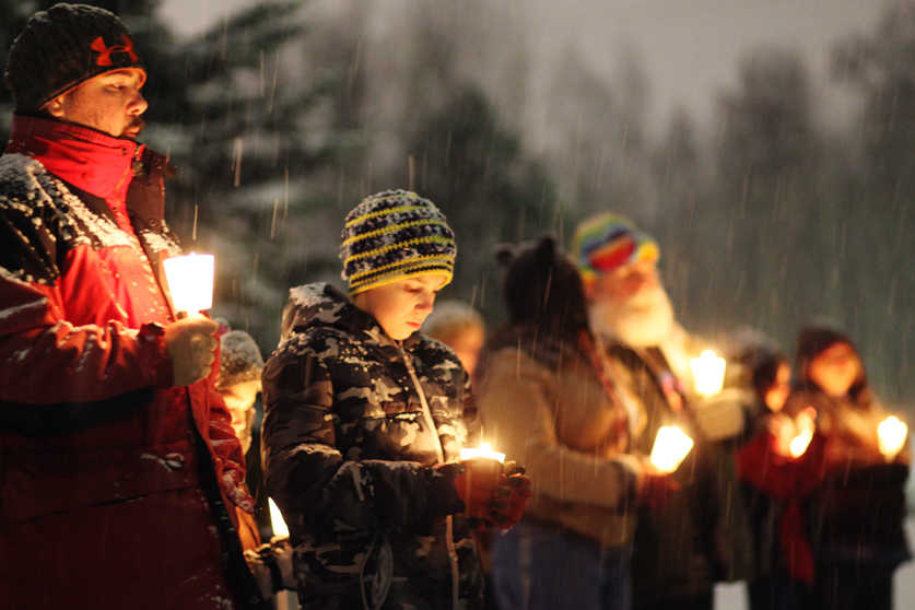 Ben Boettger/Peninsula Clarion Attendees stand in the snow during the 6th annual candlelight vigil for homeless youth on Thursday, Nov. 19 at Soldotna's Farnsworth Park.