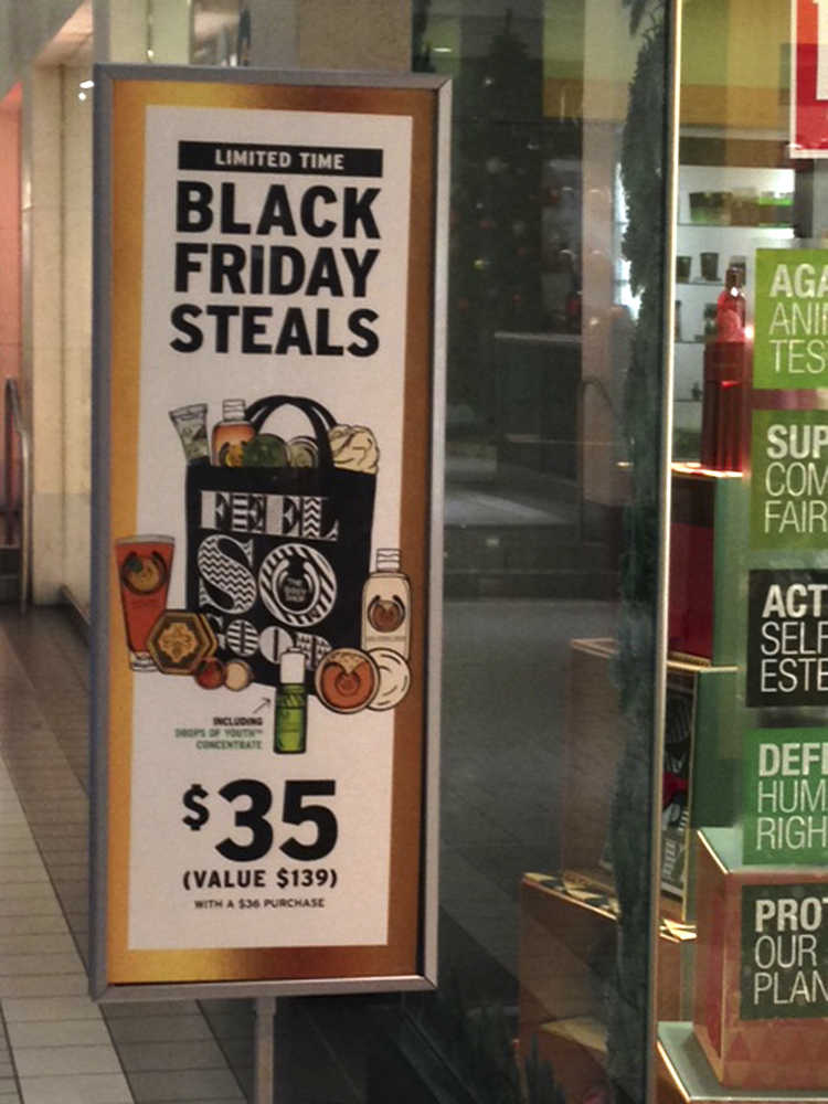 In this photo taken Tuesday, Nov. 24, 2015, sale signs for Black Friday are seen at the Fifth Avenue Mall in downtown Anchorage, Alaska. While Alaskans living in bigger cities can take part in madness in the nation's biggest shopping day, Black Friday in rural Alaska doesn't mean long lines and pushy shoppers ready to do battle for sweet deals. (AP Photo/Rachel D'Oro)