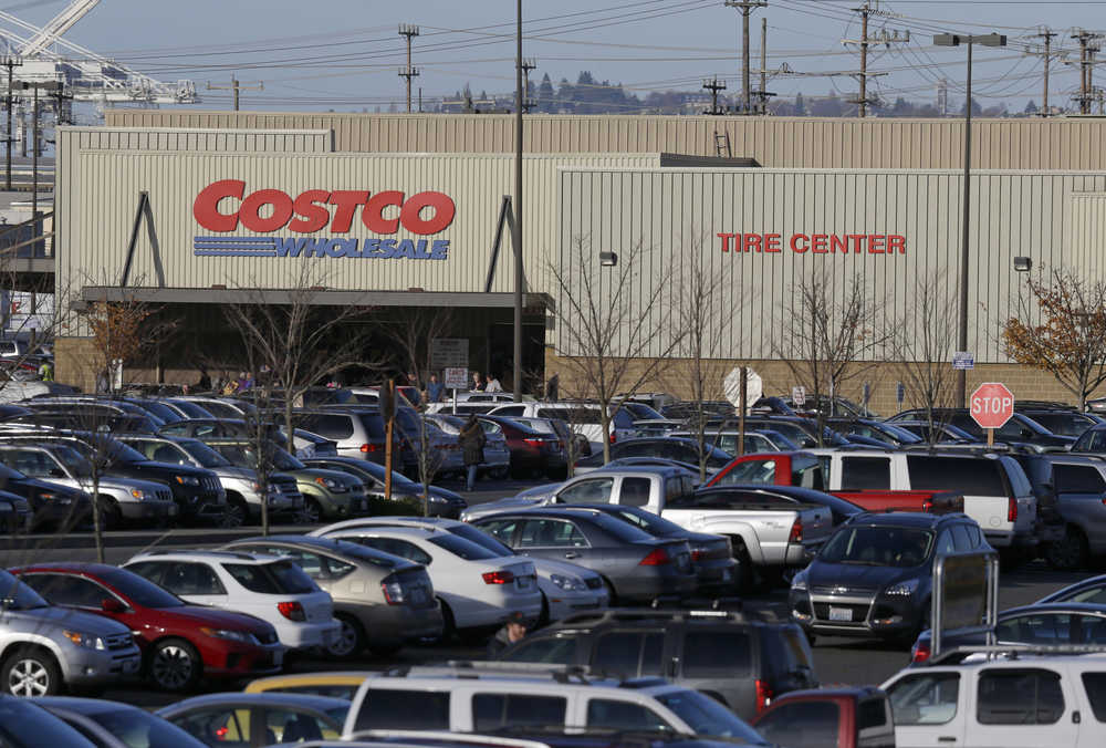 Cars fill the parking lot of a Costco store, Tuesday, Nov. 24, 2015, in Seattle. Health authorities say chicken salad from Costco has been linked to at least one case of E. coli in Washington state.  (AP Photo/Ted S. Warren)