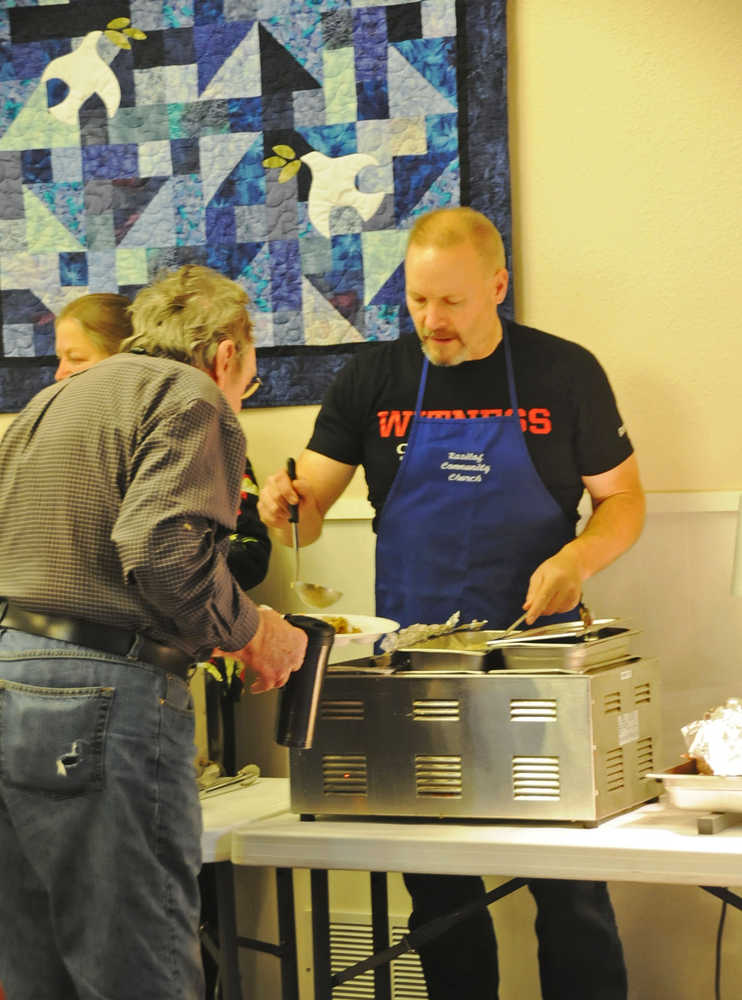 Photo by Elizabeth Earl/The Peninsula Clarion Doug Hayman, the principal of Tustumena Elementary, volunteers to serve Thanksgiving dinner at the Kasilof Community Church Thursday. The church partnered with Rocky's Cafe to serve a free dinner to the public.