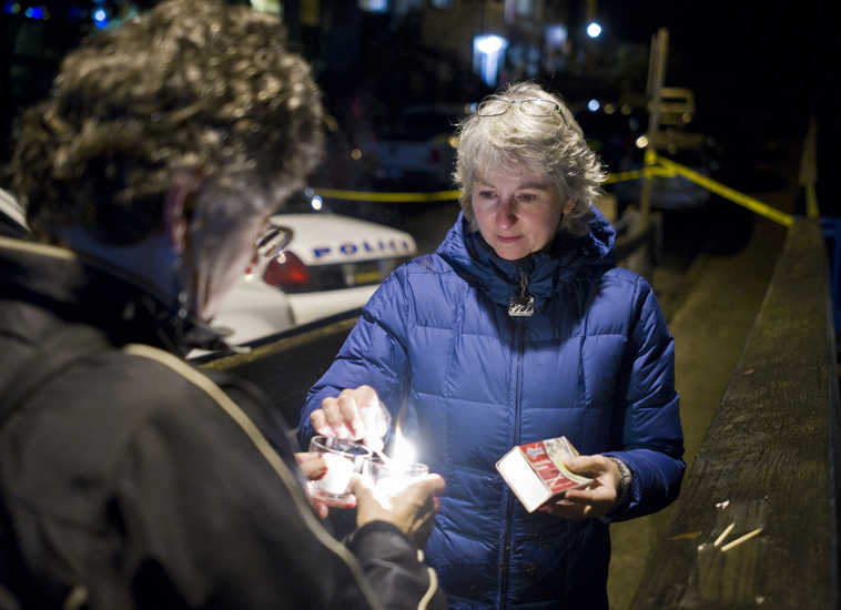 In this photo taken Monday night, Nov. 30, 2015, DJ Thomson, right, and Joyce Levine light candles on Kennedy Street after hearing about the death of Mayor Stephen "Greg" Fisk in Juneau, Alaska. Fisk, the newly elected mayor of Alaska's capital city, was found dead in his home Monday. Circumstances surrounding the death were not immediately known.  (Michael Penn/The Juneau Empire via AP) MANDATORY CREDIT