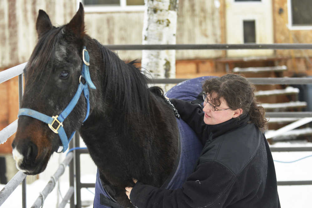 Ben Boettger/Peninsula Clarion Cristal Barton rubs the neck of her horse Major outside the house she shares with her mother Kim Garretson on Nov. 4, 2015 in Kenai. The Kenai Planning and Zoning Commission denied Garretson a conditional use permit needed to legally keep Major in Kenai; she will appeal the decision on Dec. 8. Because Barton is autistic and the horse is prescribed as treatment, denying the permit may be discrimination under the Fair Housing Act.