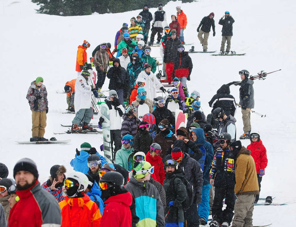 ADVANCE FOR WEEKEND EDITIONS, NOV. 21-22 - FILE - In this Nov. 20, 2012, file photo, a long line snakes back onto the mountain as of skiers and snowboarders wait to step onto the Brooks chairlift at Stevens Pass, Wash., ski area for the first run of the season. Many major ski resorts plan to open around the Thanksgiving holiday weekend. There's still time to get yourself in shape to enjoy the good snow when it piles up by mid-December. I've compiled a few good reasons to get off your duff and tune up your body. (Mark Mulligan/The Herald via AP) MANDATORY CREDIT