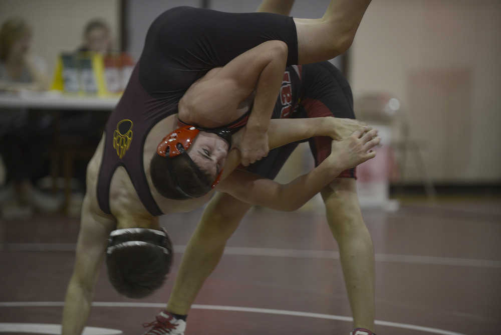 Photo by Joey Klecka/Peninsula Clarion Kenai Central's Jacob Anderson works over Grace Christian wrestler Todd Knell in the 132-pound bout of the seventh-place dual at the North-South Duals tournament Saturday at Soldotna Prep.