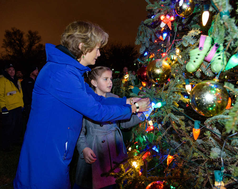 Photo courtesy Shona DeVolld Anna DeVolld and her sister Sara DeVolld pose with Sen. Lisa Murkowski in front of the banner that was sent to Washington, D.C. along with the Capitol Christmas Tree, Saturday, Oct. 31, in Anchorage, Alaska.