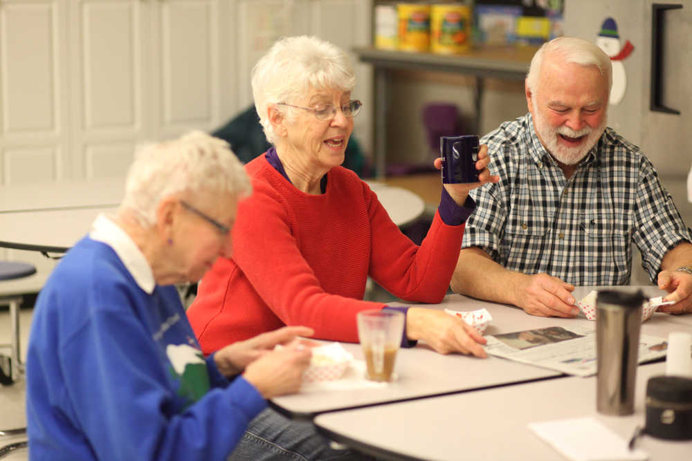 Photo by Kelly Sullivan/ Peninsula Clarion (Left) Nancy Cranston, Susan Smalley, Hal Smalley enjoy sit down together and eat the biscuits and gravy they cooked Wednesday, Dec. 9, 2015, at Kenai Alternative High School in Kenai, Alaska.
