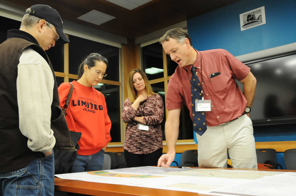 Photo by Elizabeth Earl/Peninsula Clarion Steve Noble (right), the vice president of engineering consulting firm DOWL, explained the details of the Sterling Highway improvement project to the public at an open house Wednesday at the Kenai National Wildlife Refuge Visitor's Center in Soldotna.