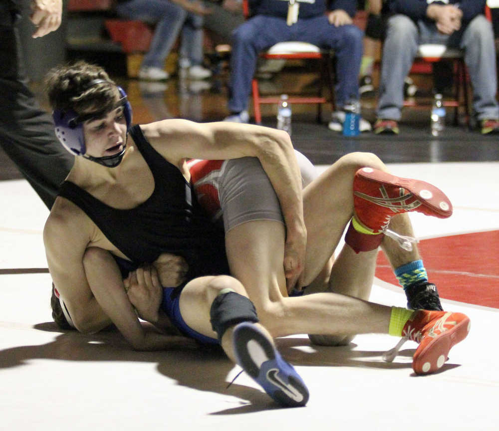 Soldotna High senior Seth Hutchison tries to roll Wasilla sophomore Isaiah Elvsaas during the 126-pound match of the championship finals of the Northern Lights Conference Championships Dec. 12 at Wasilla High School. Hutchison edged Elvsaas 5-4 in the match to win his fourth career region title.