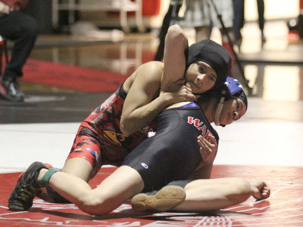 Kenai Central's Natalie Chavez tries to push Wasilla's Heidi Warner to her back during the girls' 106-pound final of the Northern Lights Conference Championships Dec. 12 at Wasilla High School. Chavez pinned Warner in the third round to win the match.