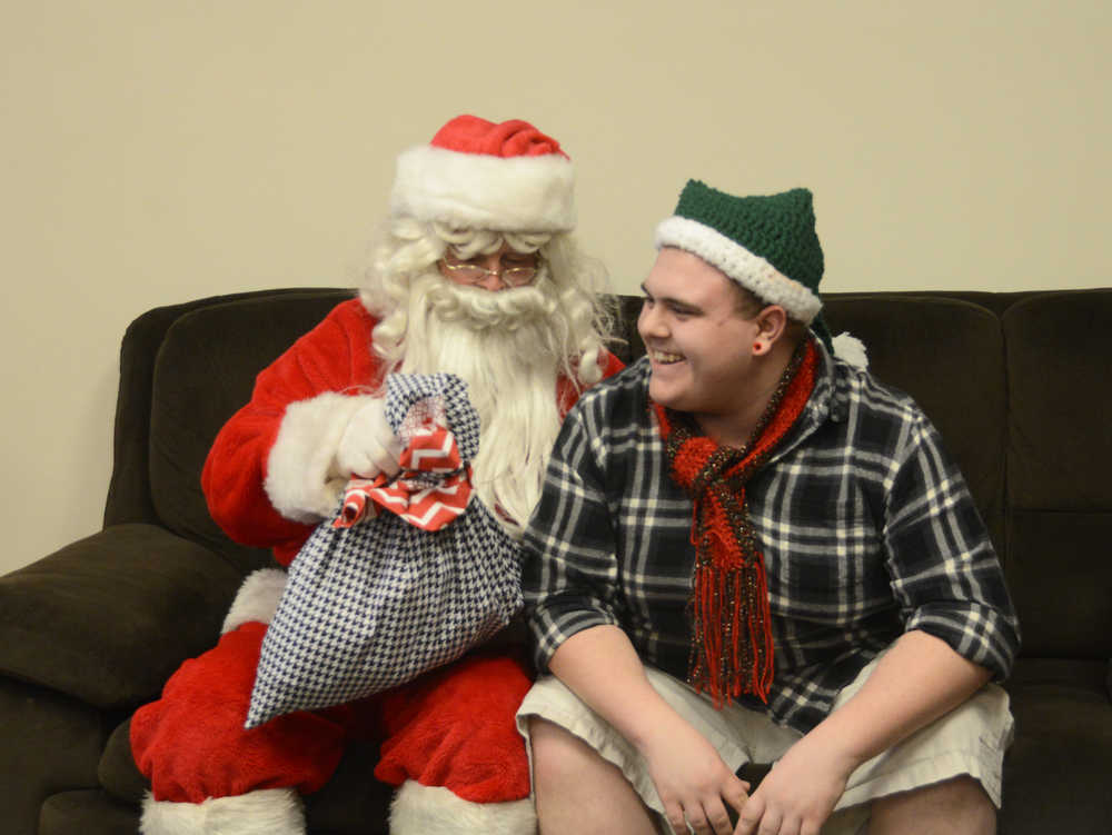 Photo by Megan Pacer/Peninsula Clarion Kenai Alternative High School senior Kody Vaught accepts a hand-made pillow case filled with treats from Hal Smalley, posing as Santa Clause, on Thursday, Dec. 17, 2015 during the school's annual Grinch Day in Kenai, Alaska.