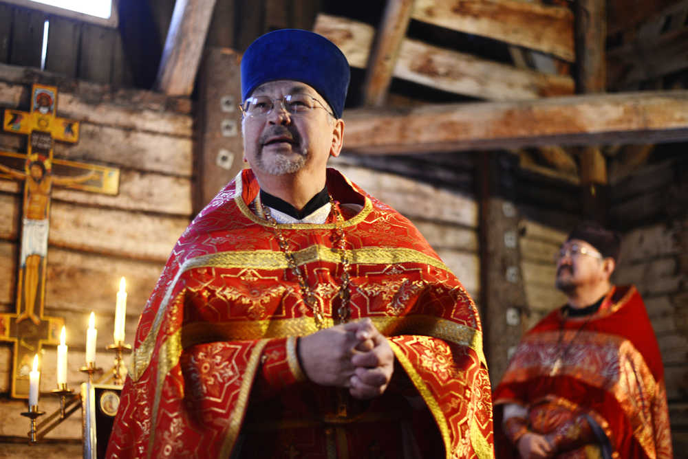 Ben Boettger/Peninsula Clarion Father Andrew Thomas of Kenai's Holy Assumption of the Virgin Mary Russian Orthodox Church speaks to the small congregation gathered for Divine Liturgy in the St. Nicholas Chapel on Saturday, Dec. 19 in Kenai. Behind him stands Father Victor Nick of Ninilchik.  "There is no other church like this in Alaska," Father Thomas said of the chapel, which was built in 1906 over the graves of three missionary monks who came to the Kenai area in the mid-1800s.