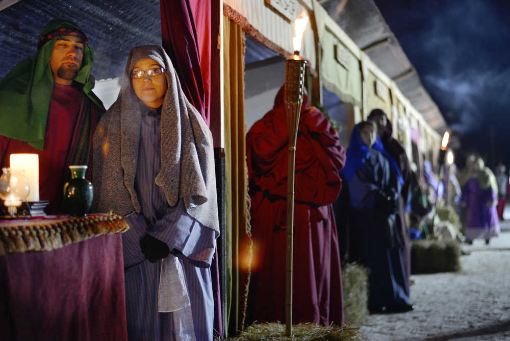 Ben Boettger/Peninsula Clarion Candle merchants Lucas and Jessica Loggins stand in a row of simulated market booths in the College Hieghts Baptist Church recreation of Biblical Bethlehem on Friday, Dec. 18 in Soldotna. The church's Bethlehem Revisited exhibit will be open nightly until Dec. 21.