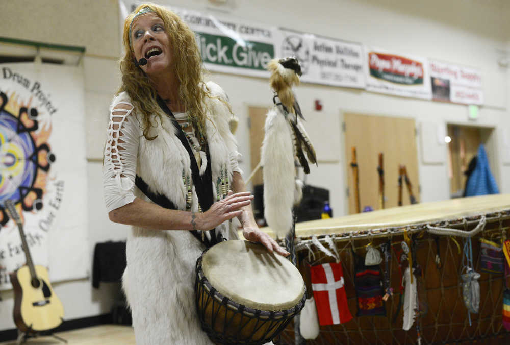 Photo by Megan Pacer/Peninsula Clarion Sterling resident Sabrina Hensley examines a doll that was passed through a small crowd during a concert on Sunday, Dec. 20, 2015 at the Sterling Community Center in Sterling, Alaska. The concert featured songs from "Holy Ground," a new CD by White Eagle Medicine Woman.