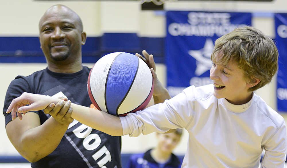 Photo by Rashah McChesney/Peninsula Clarion Les "Pee-Wee" Harrison, founder of the Portland-based Showtime Athletics and former Harlem All-Star, walks Kai Mckibben, 14, through a trick during a presentation for a group from the Kenai Peninsula Youth Court on Monday Dec. 21, 2015 in Soldotna, Alaska.