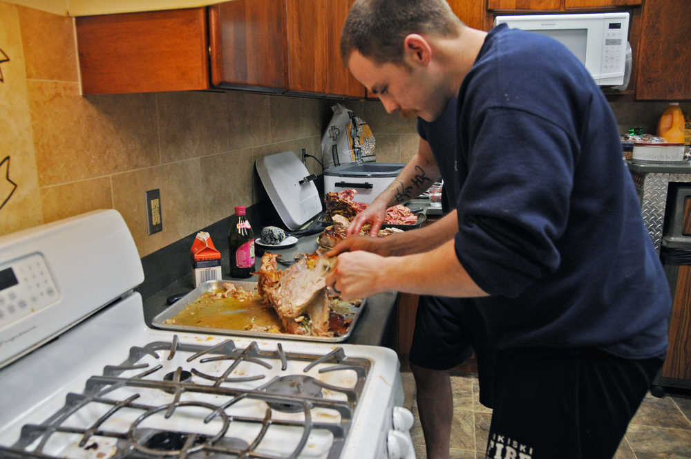 Photo by Elizabeth Earl/Peninsula Clarion Firefighter Nate Nelson prepares the turkey for the joint Central Emergency Services Christmas dinner Friday afternoon. The volunteers and staff from the various stations and their families come to the Soldotna station and share in a holiday meal.