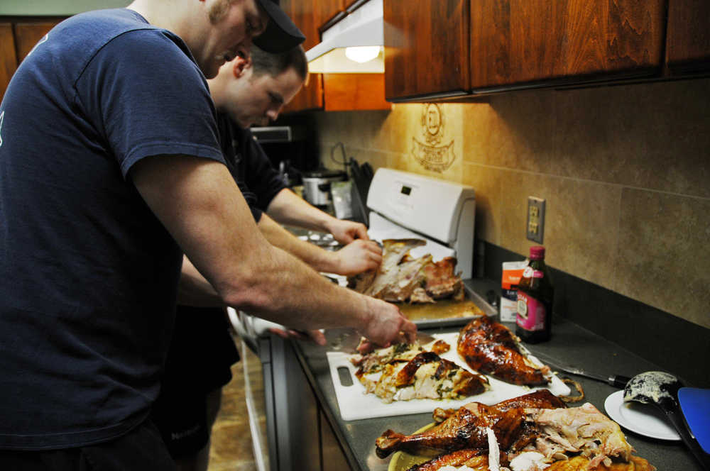 Photo by Elizabeth Earl/Peninsula Clarion Firefighters Matt Seizy (front) and Nate Nelson (back) took on the task of dividing up the turkeys for the joint Central Emergency Services dinner Christmas Day.