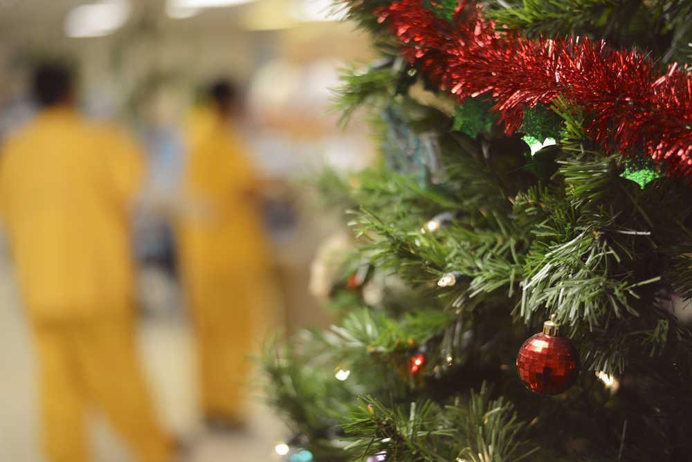 Ben Boettger/Peninsula Clarion A plastic Christmas tree stands in the main cafeteria of the Wildwood Correctional Complex as yellow-suited inmates line up for dinner on Friday, Dec. 25.