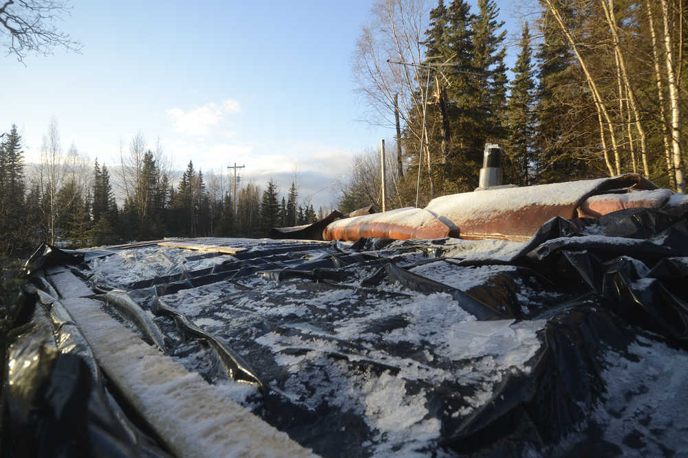 Photo by Megan Pacer/Peninsula Clarion The majority of Jessica Burch and John Schreiber's roof is clad in a tarp on Thursday, Dec. 31, 2015 in Sterling, Alaska, after a wind storm stripped a large section of their home's roof out of place.