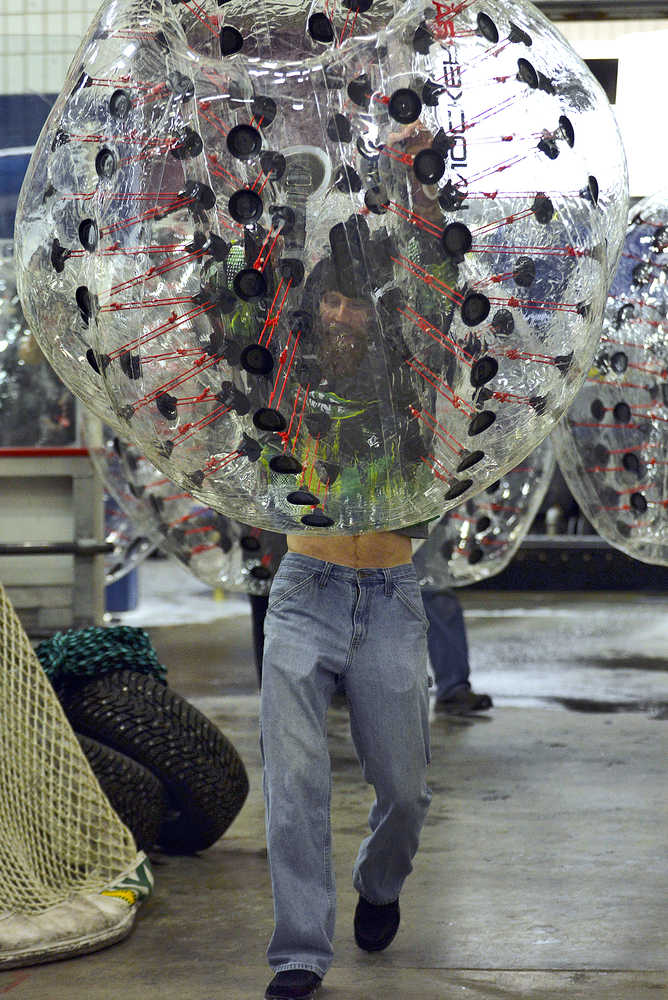 Photo by Rashah McChesney/Peninsula Clarion  A man pulls an inflated ball off of his shoulders after playing the inaugural game of "bubble soccer," during halftime at a Brown Bears game on Dec. 4, 2015 in the Soldotna Sports Complex in Soldotna, Alaska.